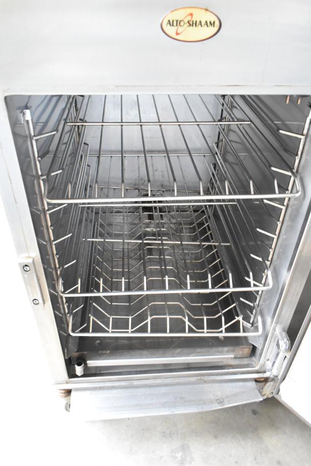 2019 Alto Shaam 1200-SK/III stainless steel commercial smoker oven with interior racks, labeled with Alto Shaam logo.