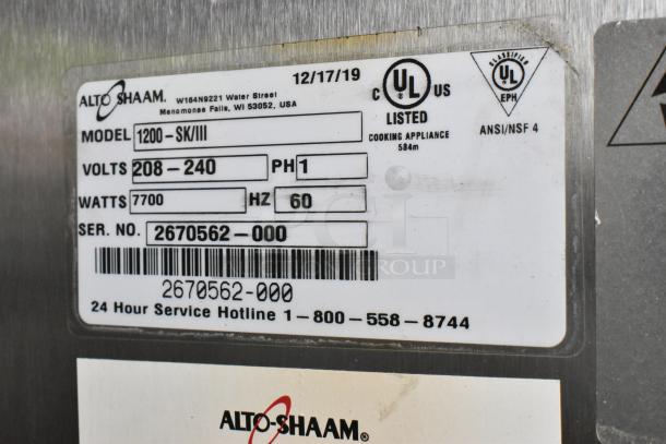 2019 Alto Shaam 1200-SK/III stainless steel smoker oven tag details voltage, phase, and serial number for auction.