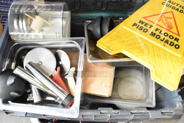 Various items including clear poly bins, kitchen utensils, drop-in bins, and a yellow wet floor sign in used condition.