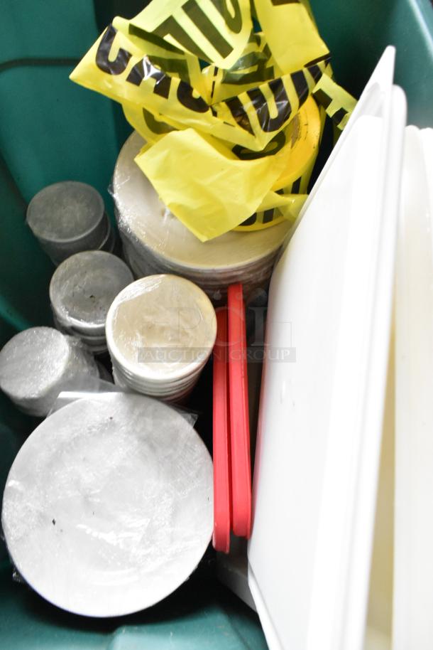 A collection of various items including poly bins, stacked utensils, drop-in bins, and yellow caution tape, in fair condition.