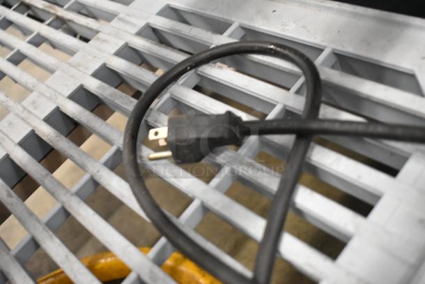 Black power cord for DeLonghi DCU72 Coffee Maker, shown on a metal grid surface. No lid included. 120V, 1 phase.