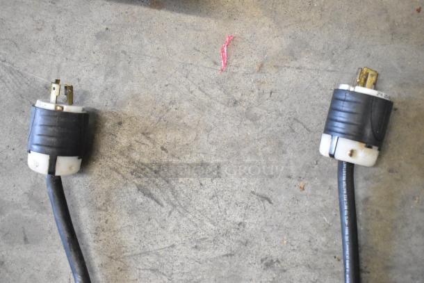 Two heavy-duty power plugs for the Taylor 339-27 soft serve ice cream machine, showing wear, on a concrete floor.