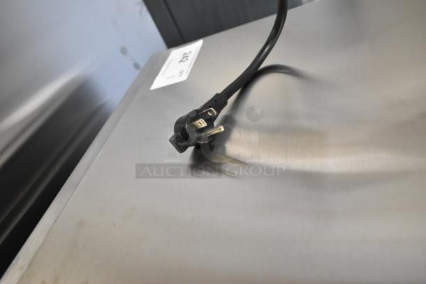 2025 Amana HDC10Y15 commercial stainless steel microwave, top view with visible power cord, model tag present.