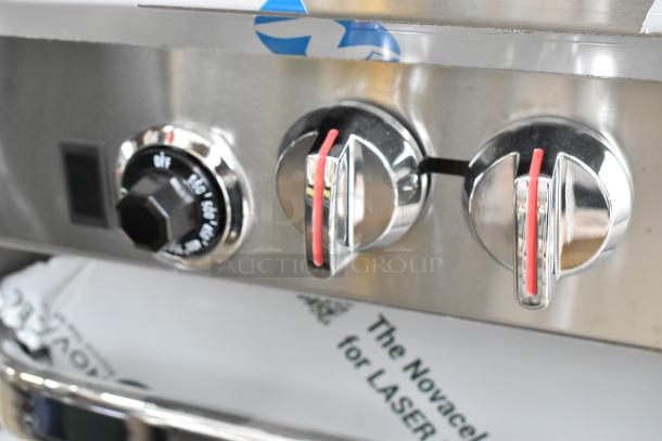 Southbend S361D range controls close-up. Stainless steel knobs, protective film, slight scratches visible.