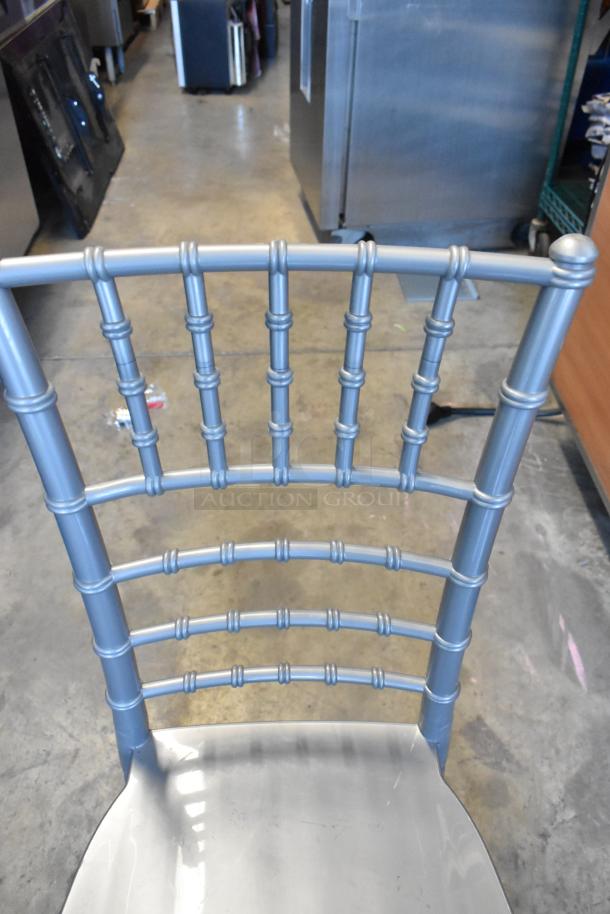 Silver Lancaster Chiavari chair, resin material, new condition, slight scratch and dent, ornate backrest design.