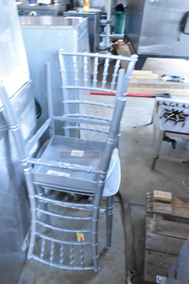 Two new Lancaster Table & Seating 164CHIARSSLV silver resin Chiavari chairs, stacked, with slight scratches and factory labels.