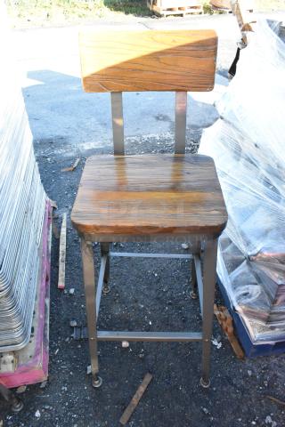 Metal bar height chair with wooden backrest and seat, in used condition. Features sturdy frame and natural wood finish.