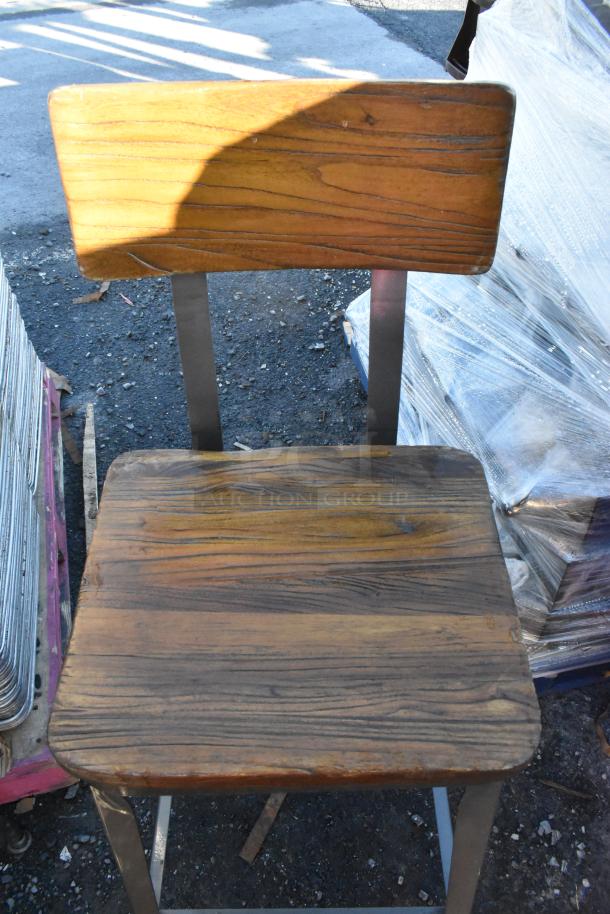 Metal bar-height chair with wooden backrest and seat. Features sturdy metal frame. Moderate wear visible on wood.