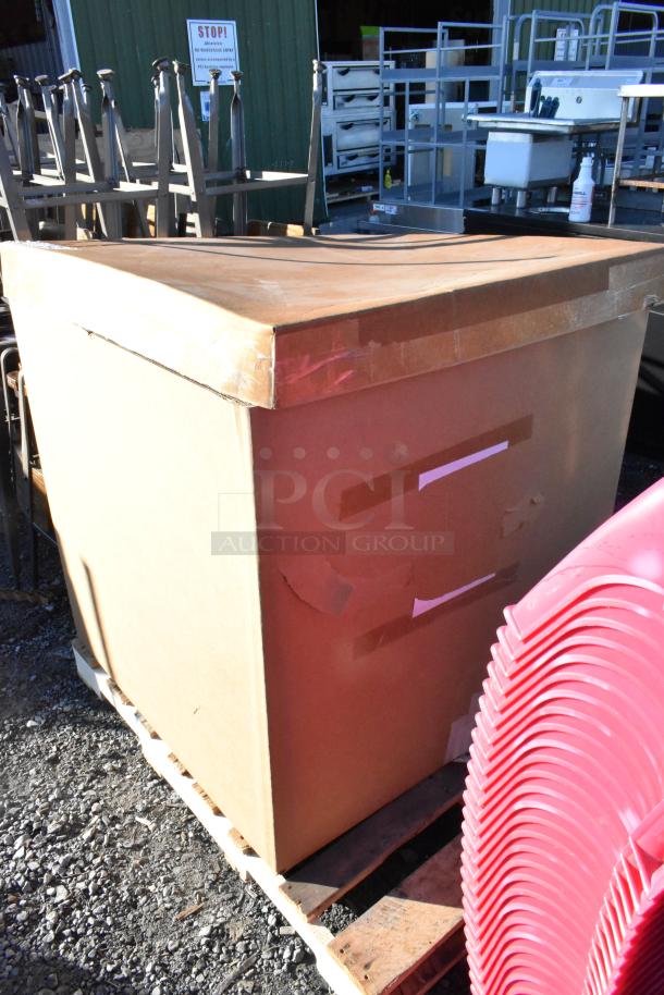 Pallet with assorted items including a large cardboard box and red plastic trays, containing stainless steel bins and white ramekins.