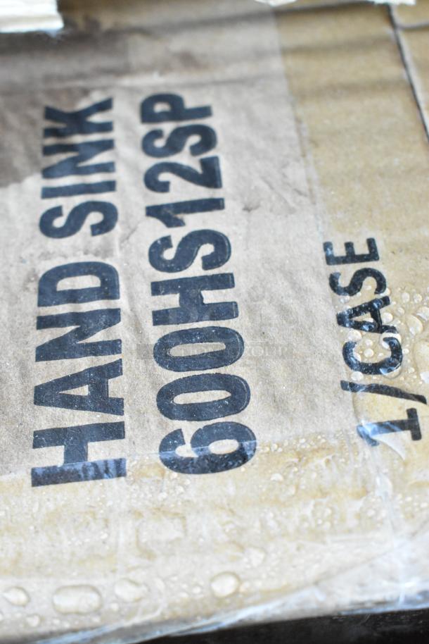 Cardboard box with "HAND SINK 600HS12SP 1/CASE" text, indicating a Regency 12"x16" wall-mounted hand sink.