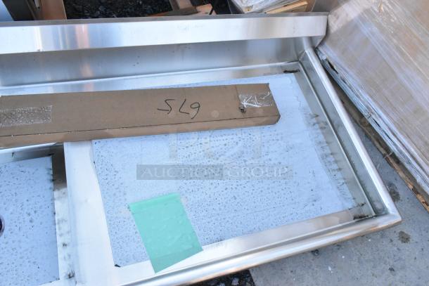 BRAND NEW Regency 600UDT60L 60" stainless steel dishtable, 16-gauge, scratches, sink on left, cardboard markings visible.