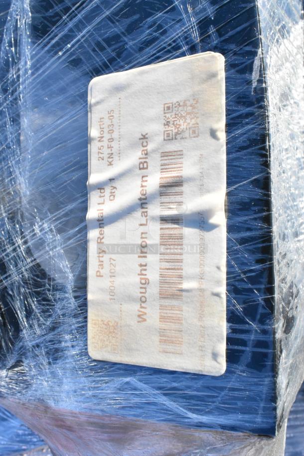 35 black wrought iron metal lanterns wrapped in plastic with label from Party Rental Ltd. Label includes barcode.