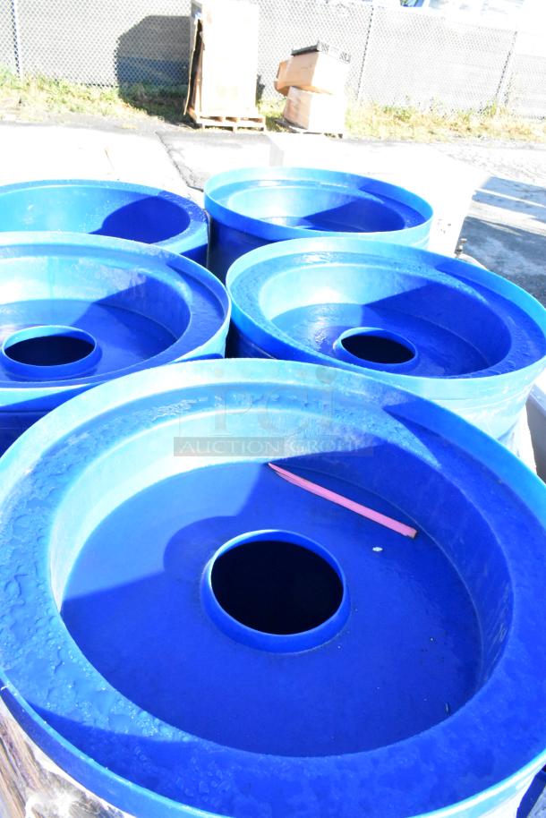 11 blue plastic trash cans, in good condition, stacked outdoors. Suitable for bulk purchase.