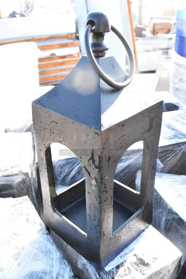 Black wrought iron lantern with ring handle, rectangular shape, and weathered texture. Auction lot of 100 items.