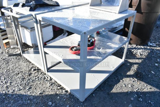 Gray metal 3-tier cart with commercial casters, brand new, slight scratches and dents, sturdy construction, versatile use.