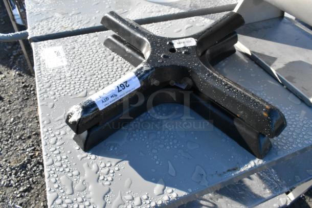 3 new black metal table base foot, model 164TB2222, scratch and dent condition, labels present, outdoor setting.