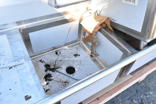 Regency 600S32424224 stainless steel 3-bay sink with dual drain boards, scratch and dent, no legs, some debris present.
