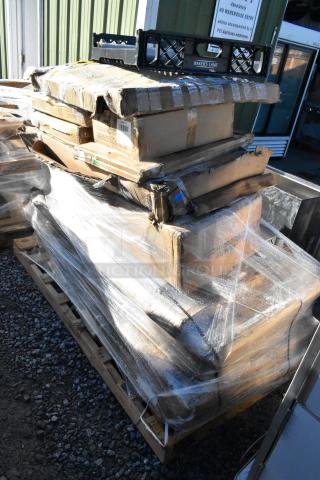 15 brand new scratch and dent items on a pallet, including stainless tables and platform truck, wrapped in plastic.