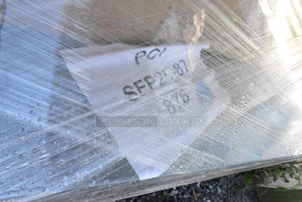 Packaged pallet of scratch and dent items, plastic-wrapped with visible label "SEPT 25 87". Items include stainless tables.