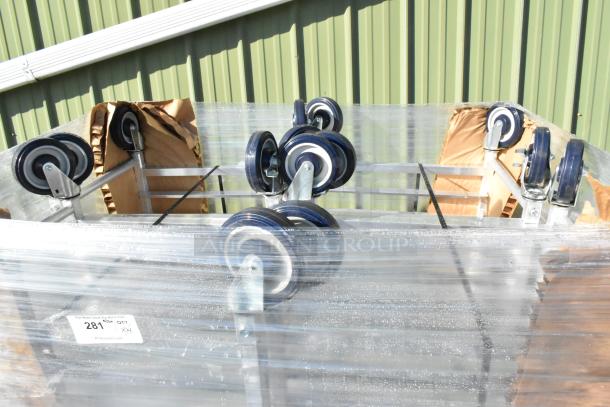 4 brand new Regency 20 Pan Aluminum Steam Table Pan Racks, assembled. Scratch and dent, wrapped in plastic with caster wheels visible.