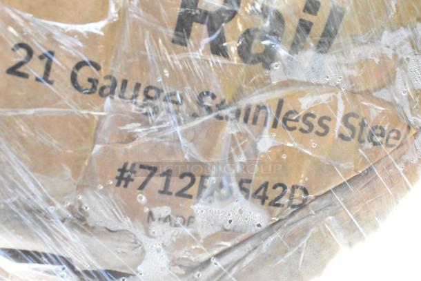 Plastic-wrapped cardboard shows text: "21 Gauge Stainless Steel" and "#712PB542D," indicating possible item specs.