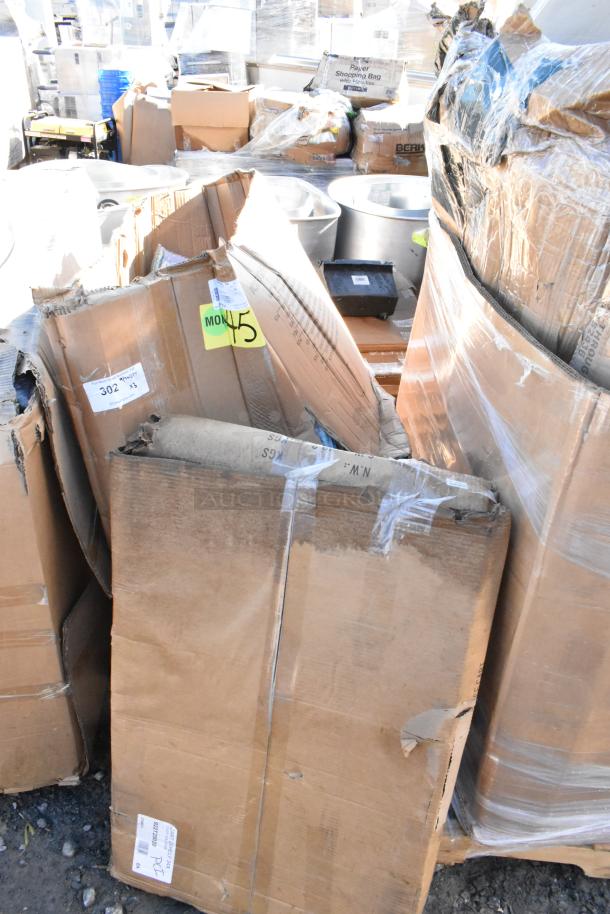 Cardboard boxes containing new scratch and dent items, including a stainless steel utility cart and bar stool. Labels show item codes and condition.