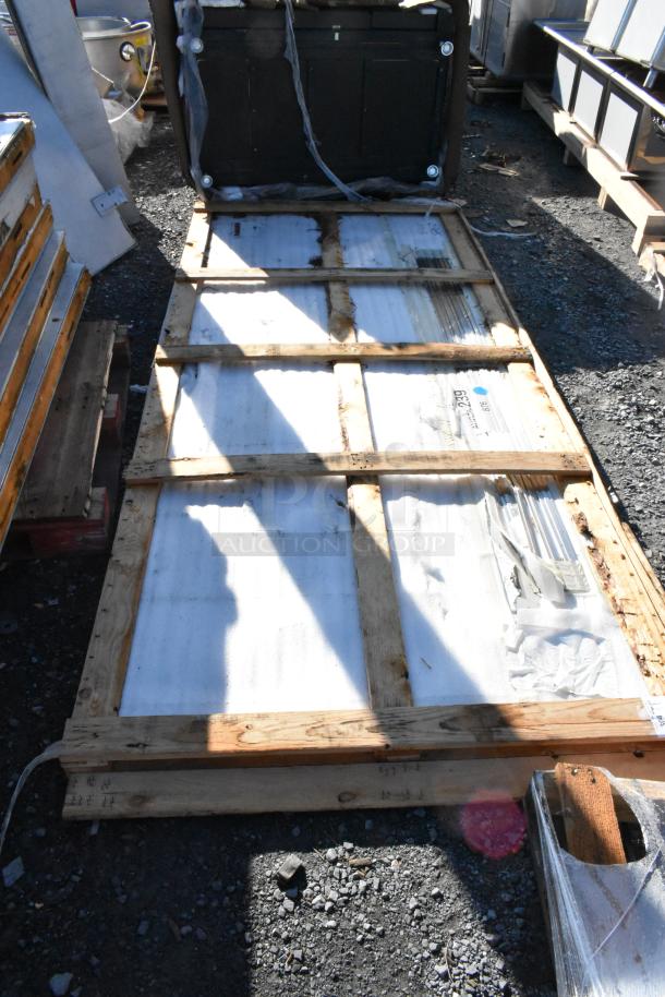 Halifax 421SSPAN410 48" x 120" stainless steel wall panel, scratch and dent condition, on a wooden pallet outdoors.