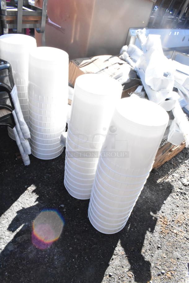 44 brand new scratch and dent white poly 9.5 liter bins, stacked, outdoor setting, potential bulk purchase benefit.