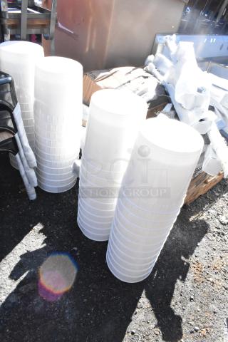 44 brand new scratch and dent white poly 9.5 liter bins, stacked, outdoor setting, potential bulk purchase benefit.
