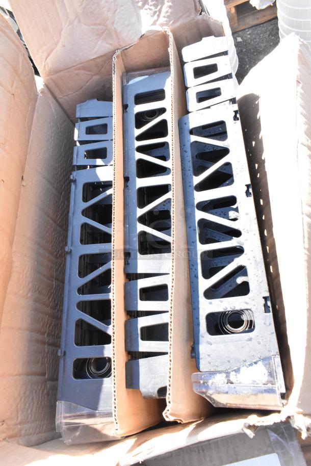 Duplicate industrial parts in a damaged box, each part with a black plastic construction and ribbed design.