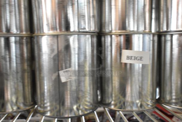 49 Pro Guard chemical cans on shelves, labeled "BEIGE." Reflective metal surface, clean, likely unused. Auction lot.