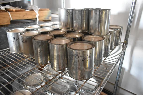 107 Pro Guard Chemicals, labeled "Gray," in metal cans on a wire shelf, indicating quantity and color variety.