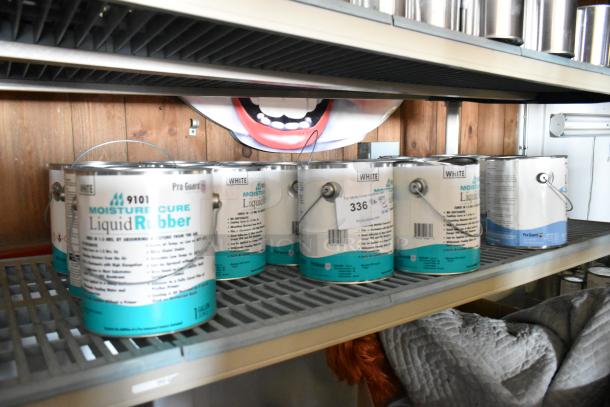16 cans of Pro Guard chemicals, including 9101 Moisture Cure White Liquid Rubber and Well Bred Brown EPDM Liquid Rubber, on a shelf.
