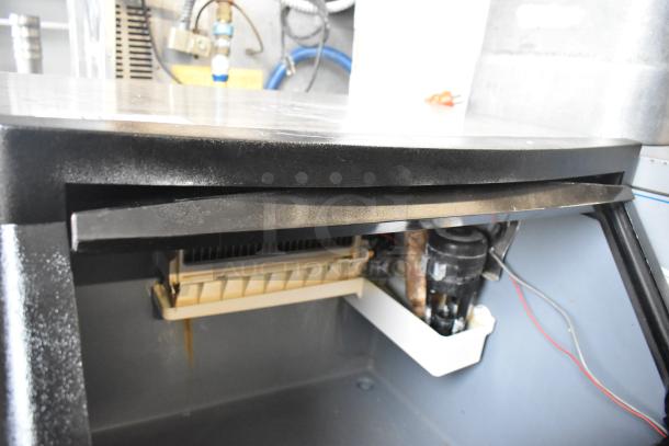 Manitowoc QY0134A stainless steel undercounter ice machine, visible inner components, shows usage wear, ideal for commercial use.