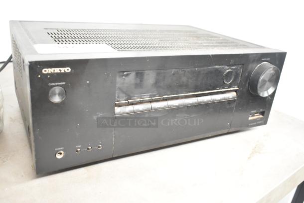 Onkyo TX-SR373 AV Receiver, black, used condition with visible wear, front panel buttons, large volume knob, headphone jack.