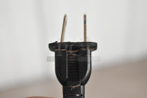 Close-up of a power plug for the Onkyo TX-SR373 AV Receiver, showing slight wear on the prongs.