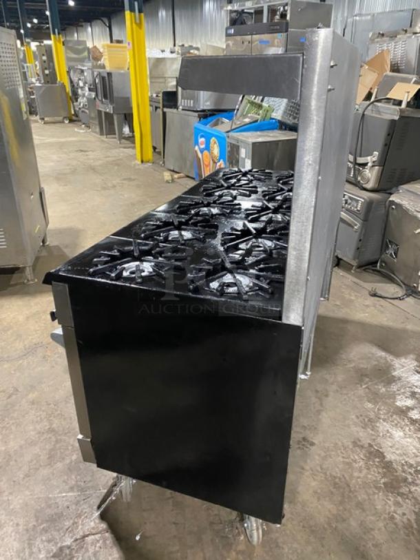 Vulcan commercial 10 burner range with double ovens, stainless steel, natural gas, backsplash, overhead salamander shelf, on casters.