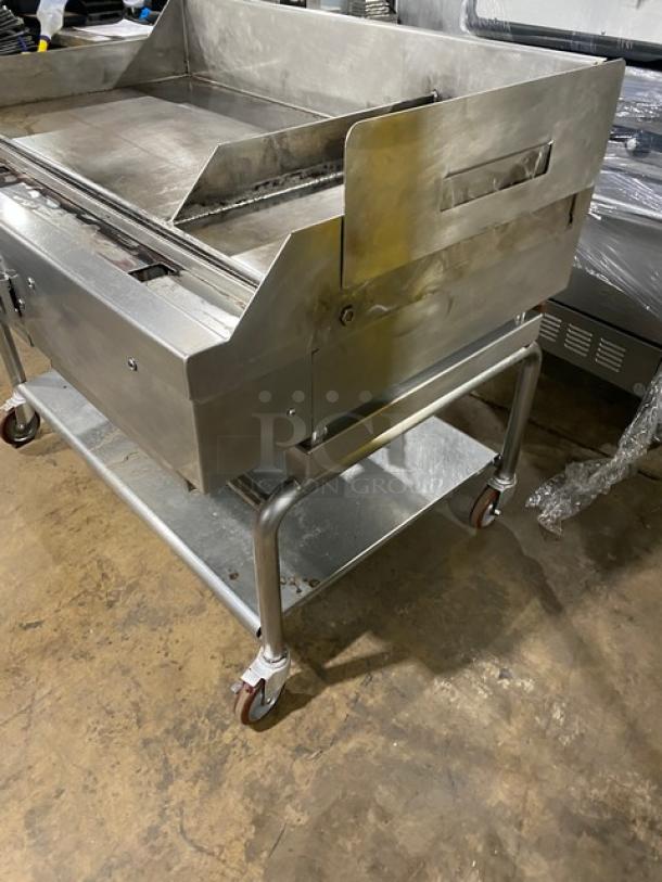 WoodStone stainless steel natural gas plancha flat griddle on casters, featuring back and side splashes, undershelf cart.
