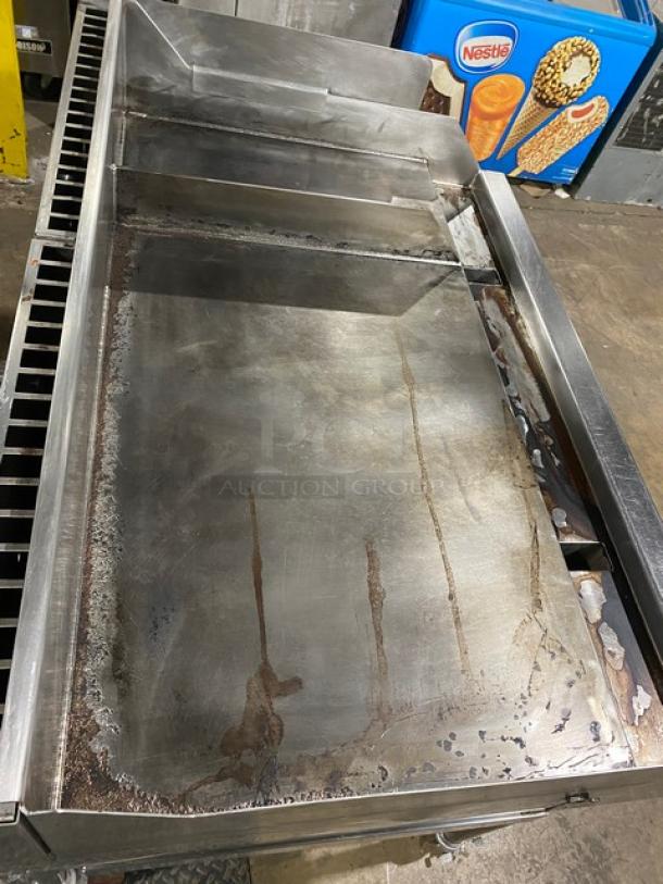 WoodStone stainless steel natural gas countertop plancha griddle with back and side splash, undershelf cart, and casters.