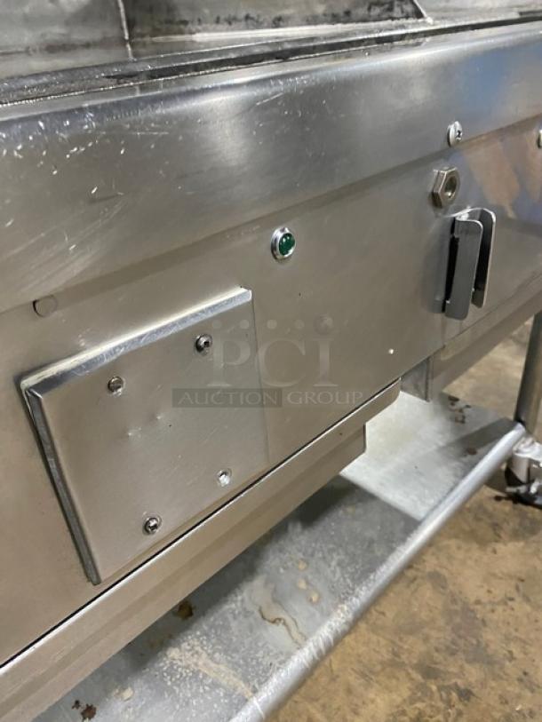 WoodStone commercial stainless steel natural gas countertop plancha griddle with back and side splash, on casters.