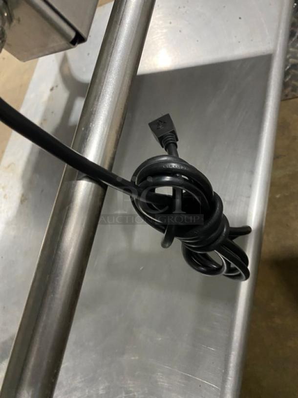 WoodStone stainless steel flat griddle with back and side splash, natural gas powered, on equipment cart with casters.