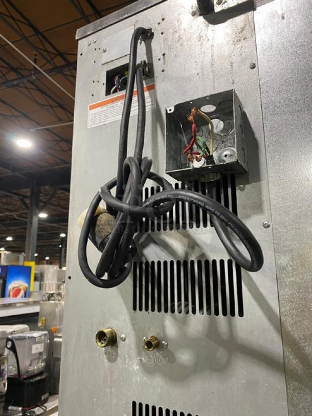 Back view of Hoshizaki KM1340MRJB500PF ice maker, showing wiring and connection ports. Stainless steel finish, on legs.