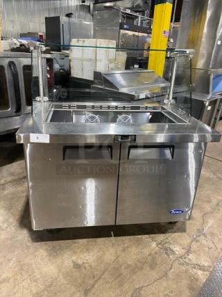 Atosa MSF8306 stainless steel 2-door refrigerated prep table with sneeze guard, poly-coated wire rack, on casters.