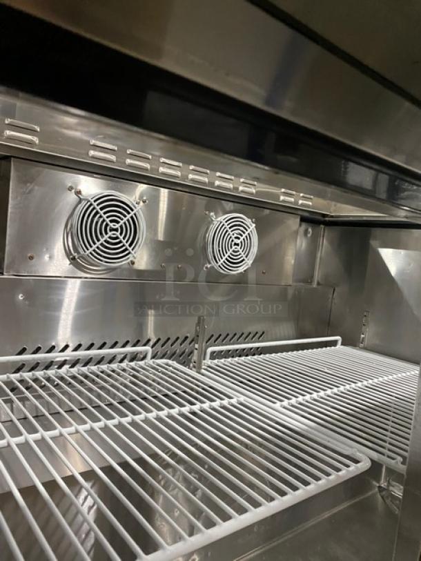 Atosa MSF8306 stainless steel 2-door refrigerated prep table interior with poly coated wire rack and fans.