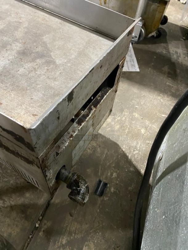 Commercial stainless steel countertop flat griddle with natural gas power. Features back and side splash, on legs. Used condition.
