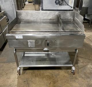 WoodStone commercial stainless steel natural gas countertop plancha griddle with back and side splash, single undershelf cart, on casters. SN: GP1B16MAY1704992.