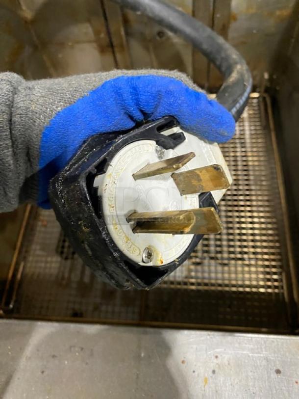 Heavy-duty plug for Frymaster FilterQuick fryer model 1FQE80U0ZQTZB17, shown with a blue-gloved hand.