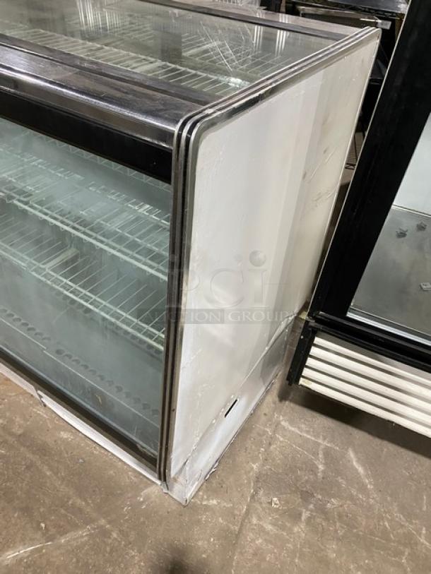 Commercial white 48" refrigerated meat deli display case with straight glass, poly coated wired rack, and rear sliding doors.