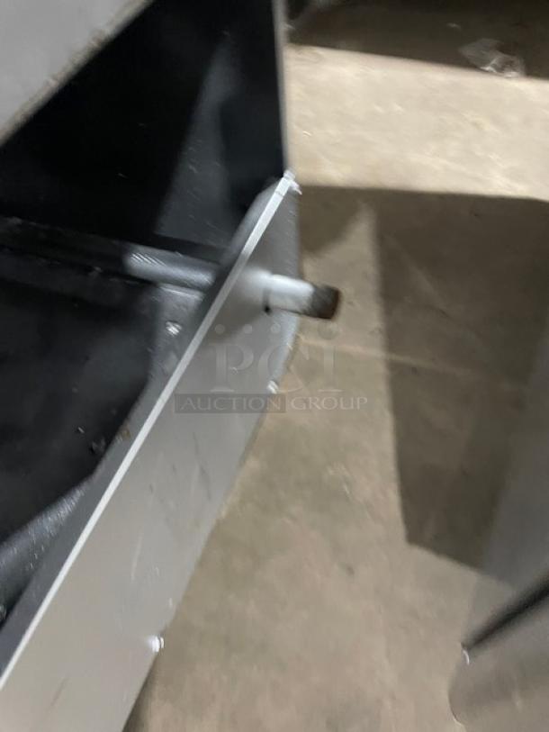 American Range stainless steel natural gas fryer with backsplash, basket hanger, and fry basket, mounted on legs.