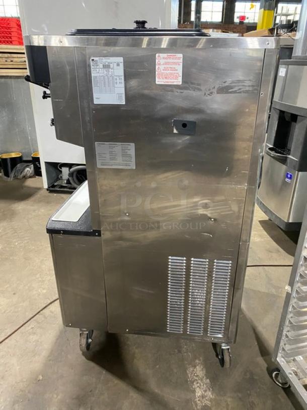 Taylor C713-33 dual flavor soft serve machine in stainless steel, 208-230V, 3 phase, on casters, with operation labels.